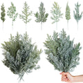 Collection of artificial pine branches, some flocked, displayed against a white background.