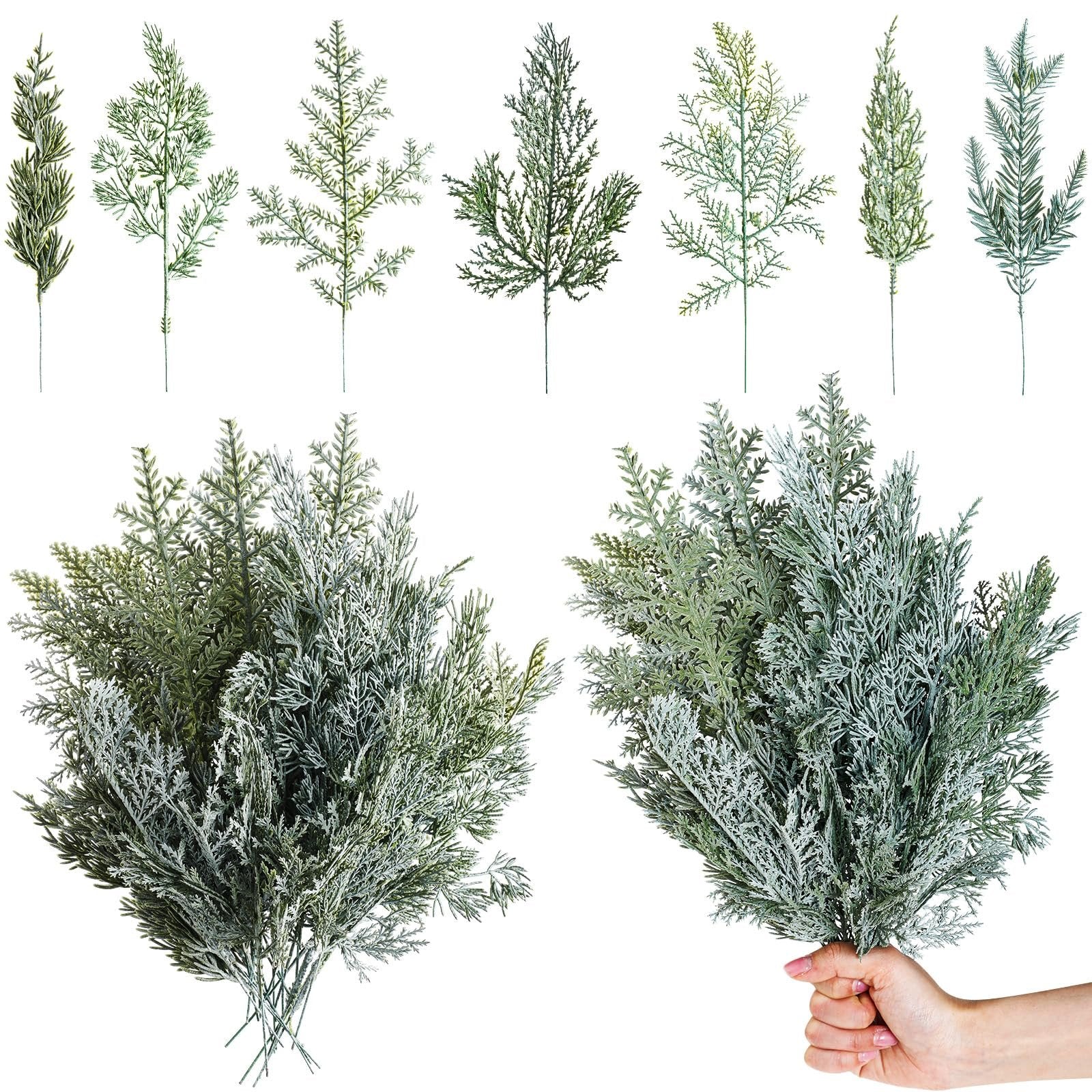 Collection of artificial pine branches, some flocked, displayed against a white background.