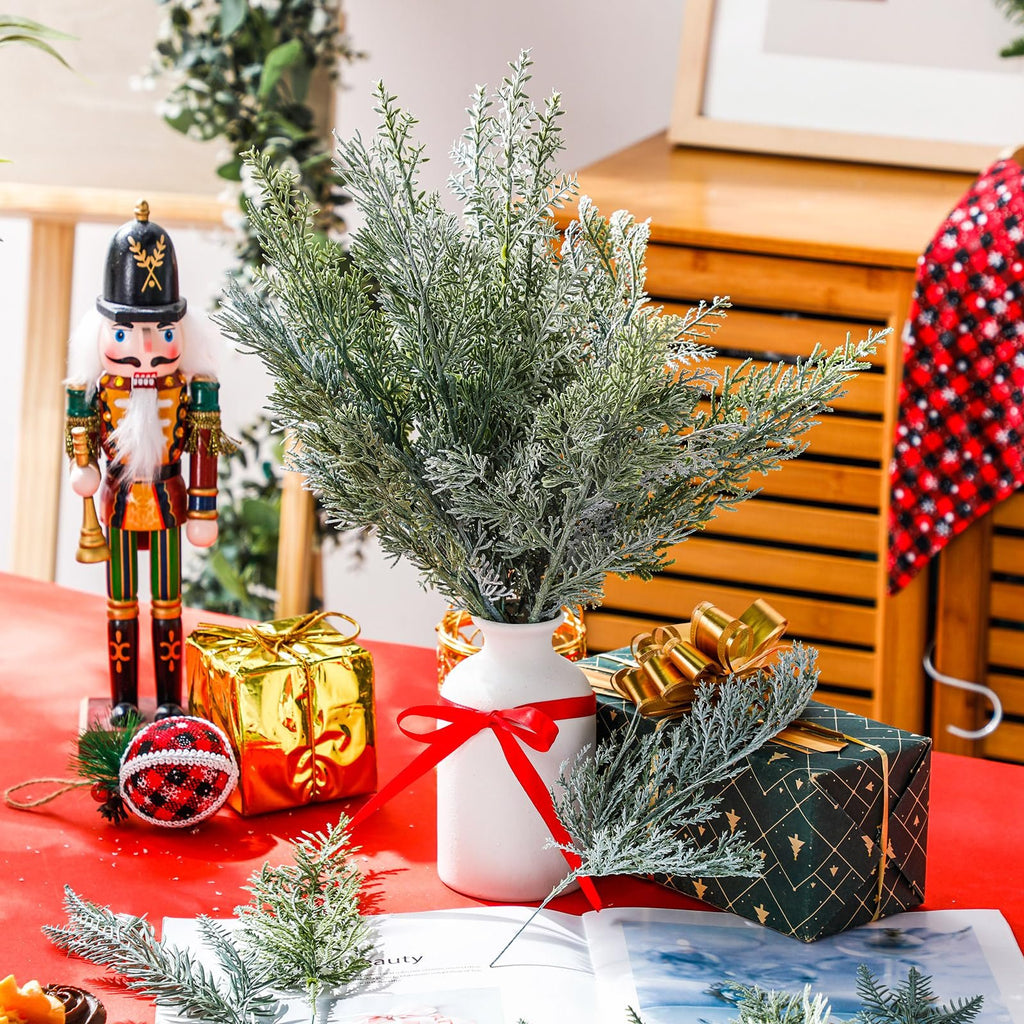 Christmas scene with flocked pine branches in a vase, nutcracker, and gifts on a red tablecloth