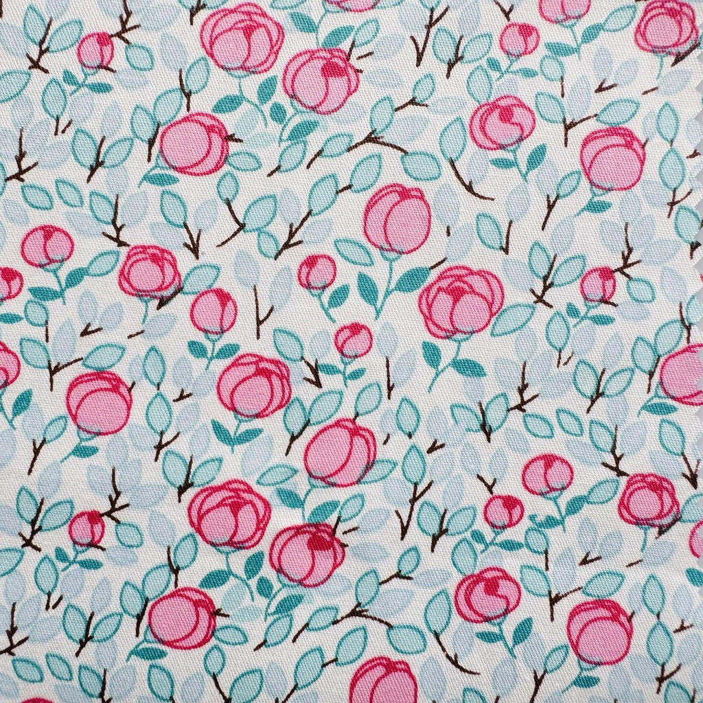 White fabric with a repeating pattern of pink roses and light blue leaves on thin brown branches.