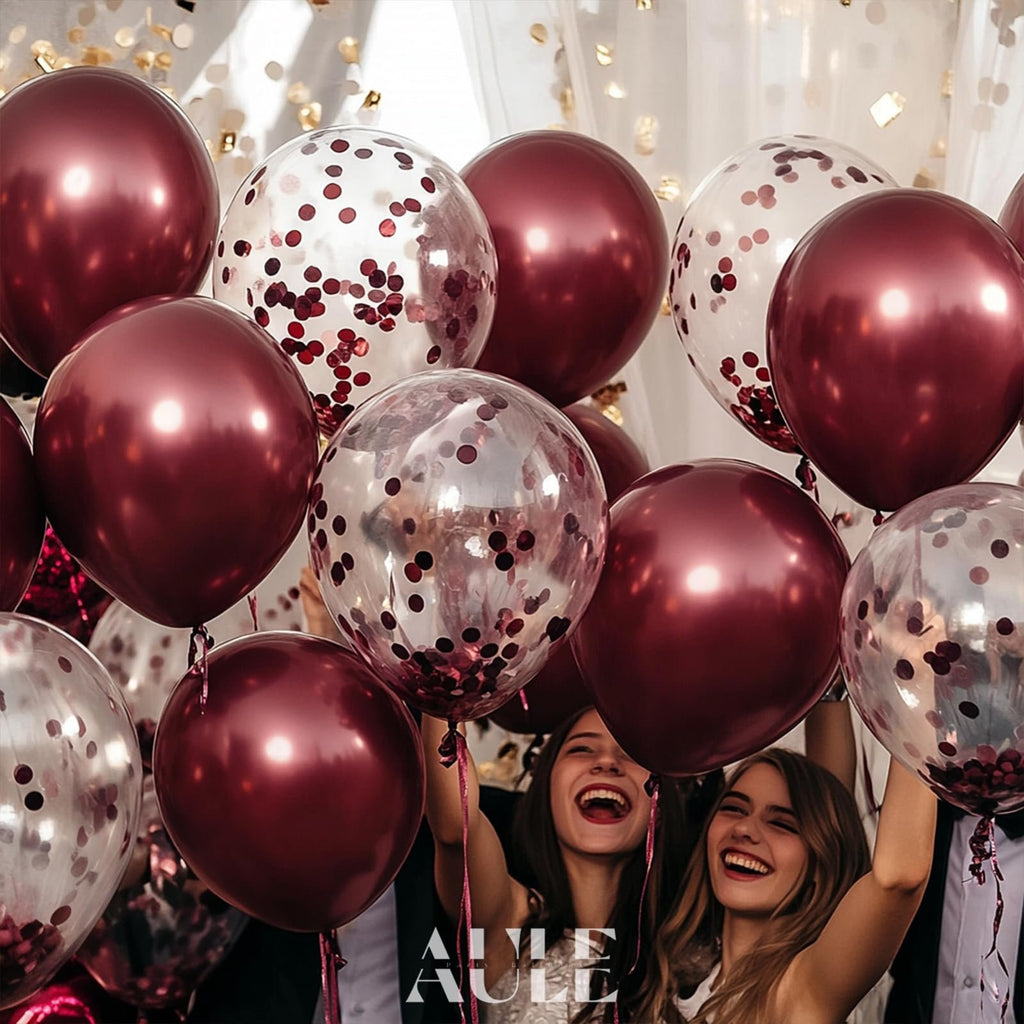 Burgundy and confetti balloons held by smiling people at a celebration