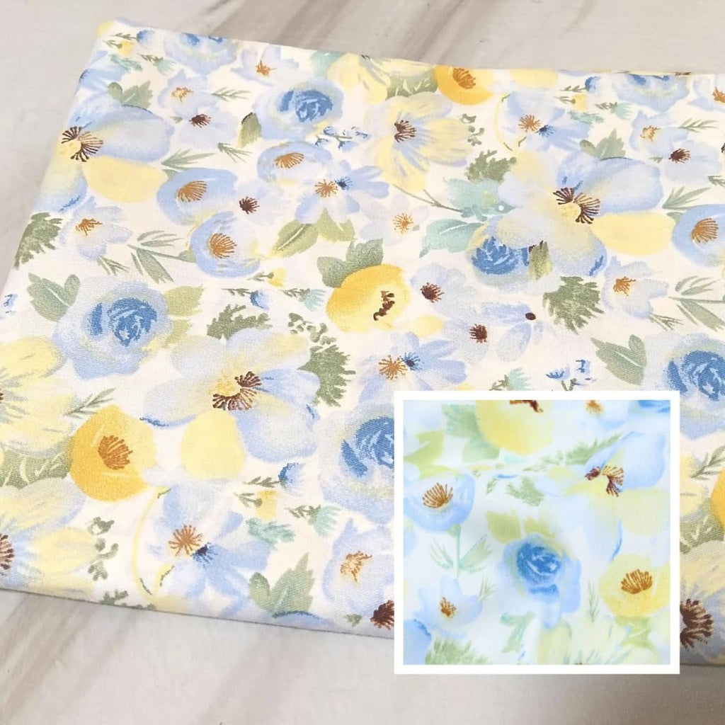 Blue and yellow floral fabric squares folded, with a close-up inset showing fabric detail.