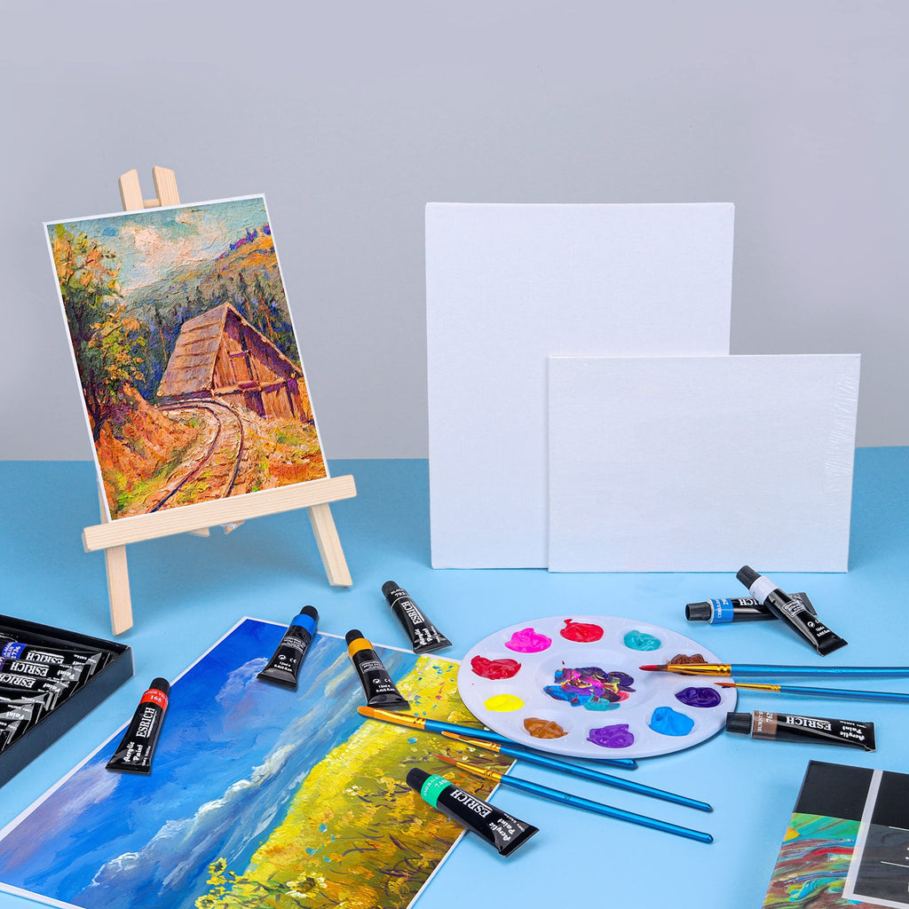 Acrylic paint set with tubes of paint, brushes, palette, and canvas panels on a blue surface.
