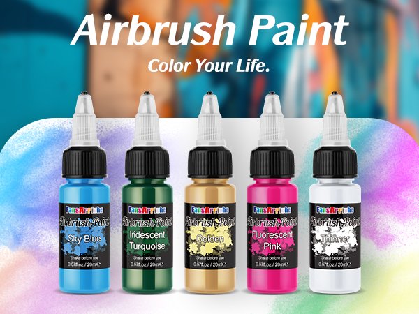 Five bottles of airbrush paint in blue, green, gold, pink, and white, with labels showing color names and brand.