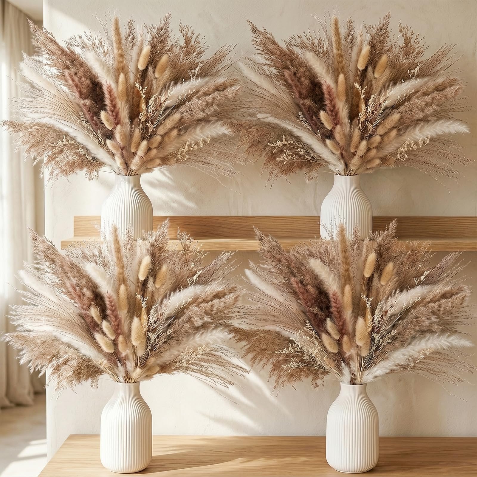 Four vases filled with dried pampas grass and bunny tail decor arranged on a wooden shelf and table.