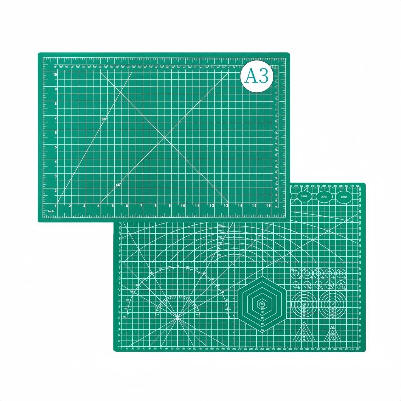 Two green self-healing cutting mats with grid lines and measurement markings, one labeled A3.
