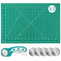Turquoise rotary cutter, five replacement blades, and a green self-healing cutting mat with grid lines and measurements.