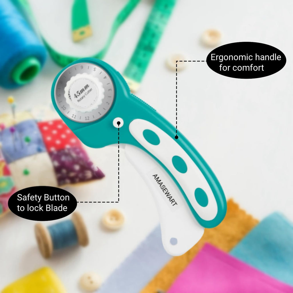 Teal and white 45mm rotary fabric cutter with sewing notions, showing safety button and ergonomic handle.