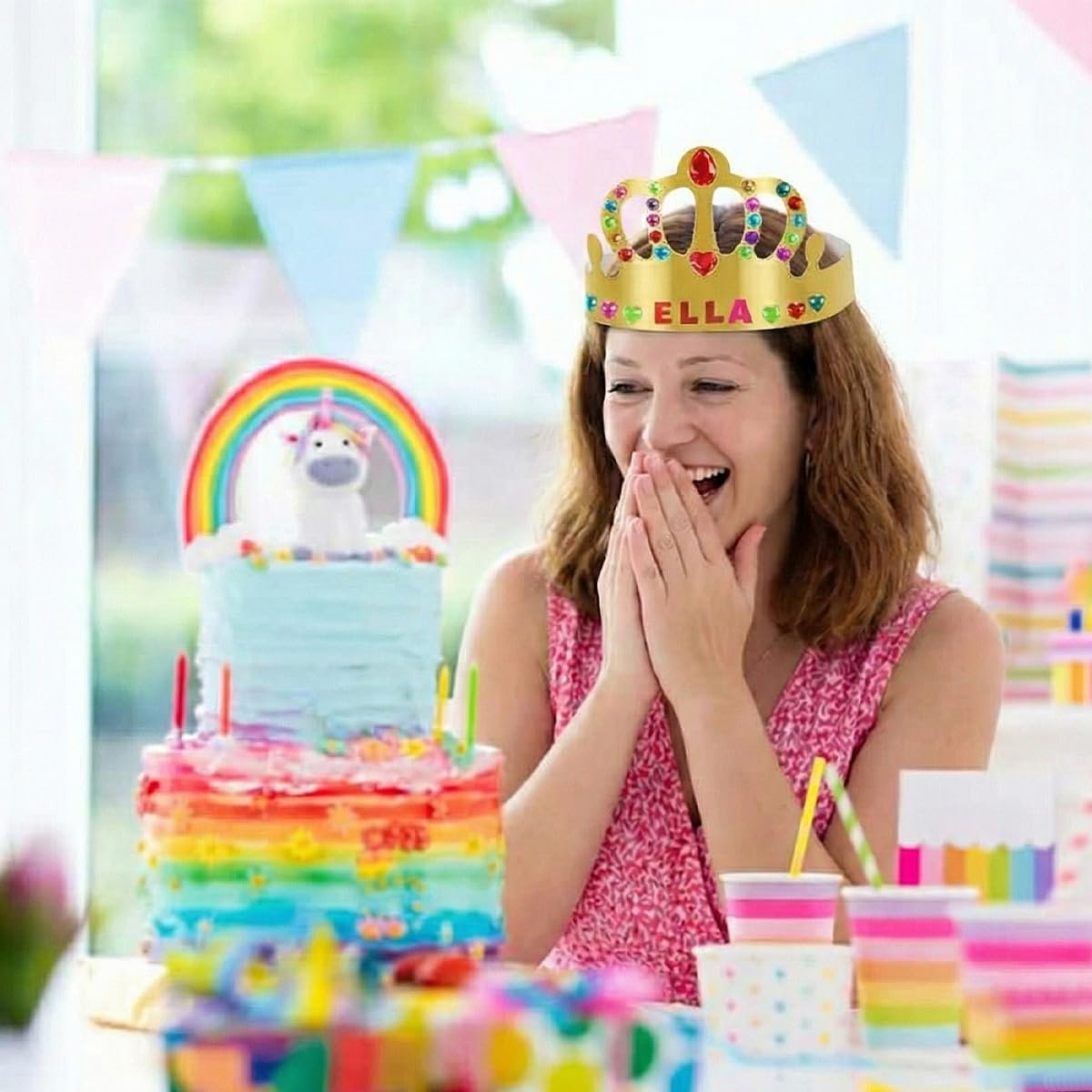 Woman wearing a jeweled paper crown at a birthday party with a unicorn cake