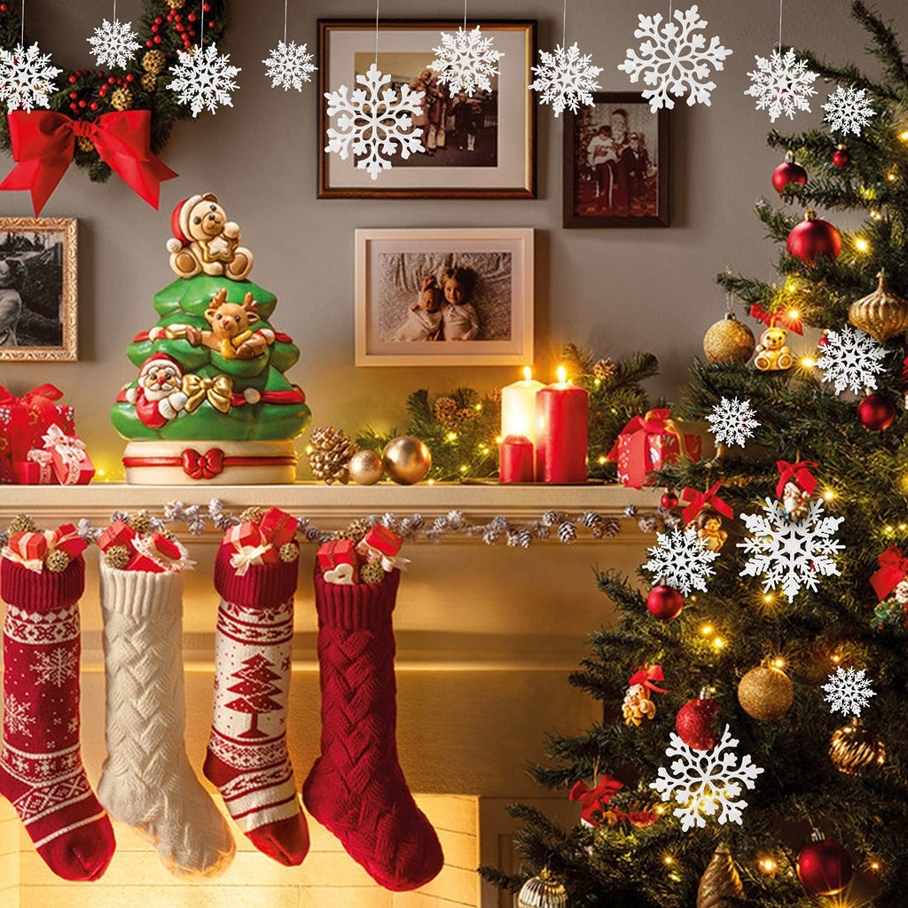 Christmas tree decorated with ornaments, stockings hung on a mantle, and snowflake decorations hanging.