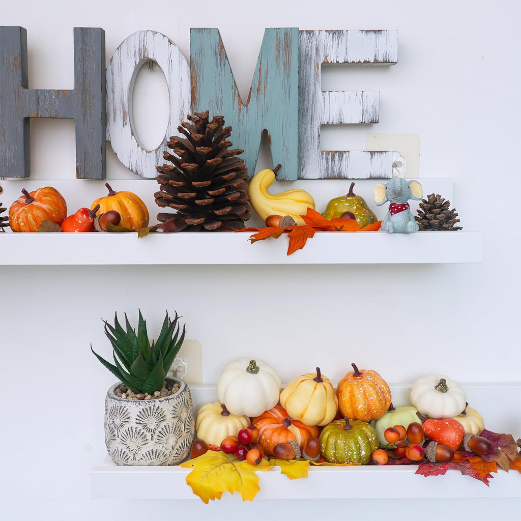 Fall harvest decor set with artificial pumpkins, gourds, acorns, pinecones, and maple leaves arranged on shelves with a decorative 'HOME' sign.