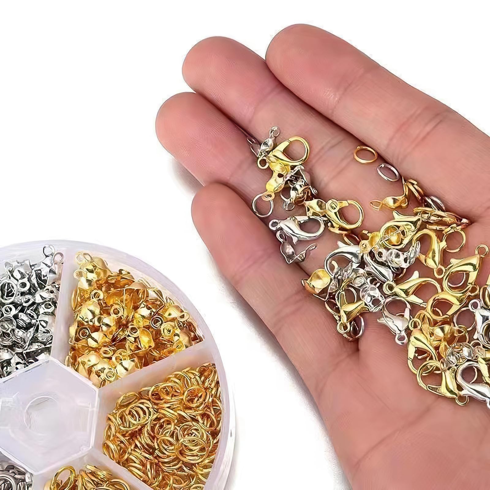 Hand holding gold and silver lobster claw clasps and jump rings from a jewelry making kit.