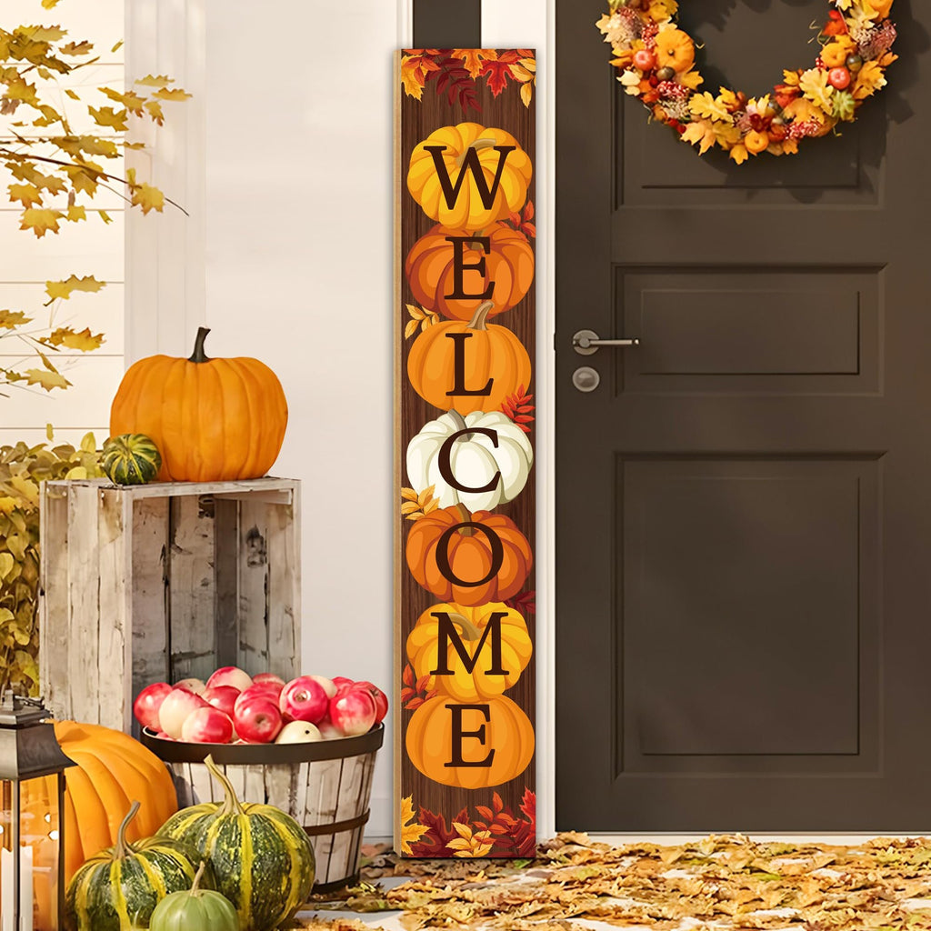 Vertical fall porch sign with pumpkins spelling WELCOME, displayed on a wooden porch with autumn decor.