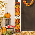 Vertical fall porch sign with pumpkins spelling WELCOME, displayed on a wooden porch with autumn decor.