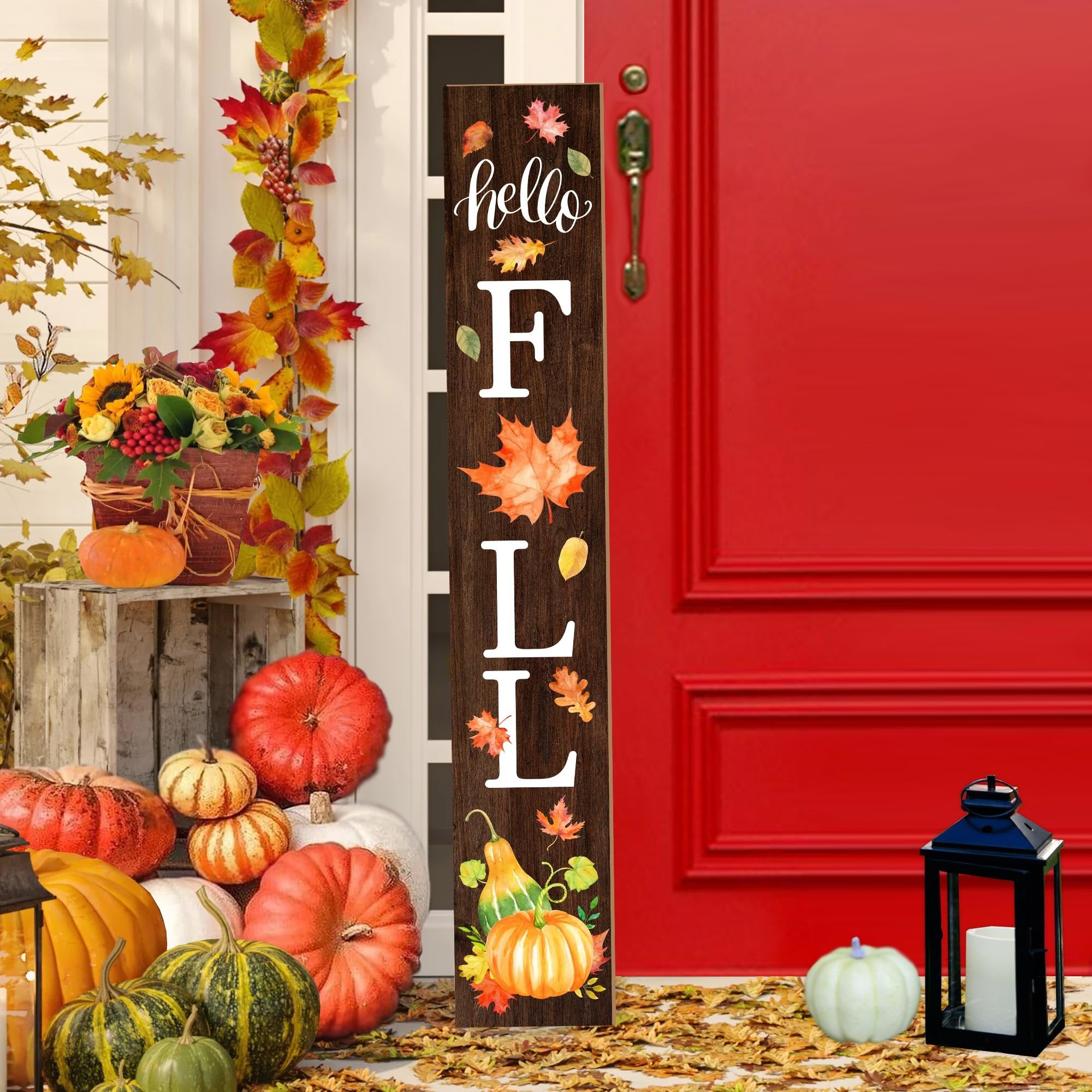 Wooden porch sign with 'hello FALL' text and autumn leaf graphics, displayed with pumpkins and a lantern.