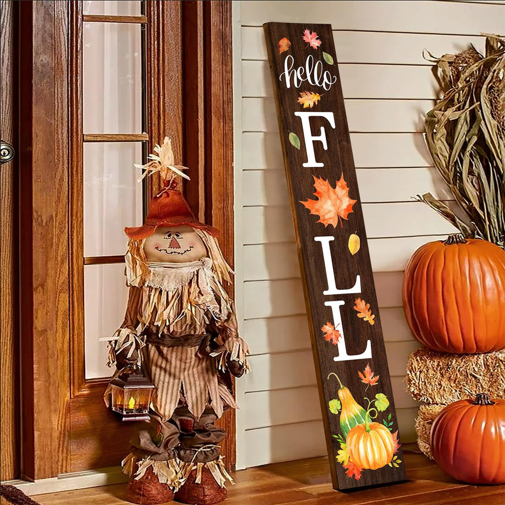 Wooden porch sign with 'hello FALL' text and autumn graphics, next to a scarecrow and pumpkins.
