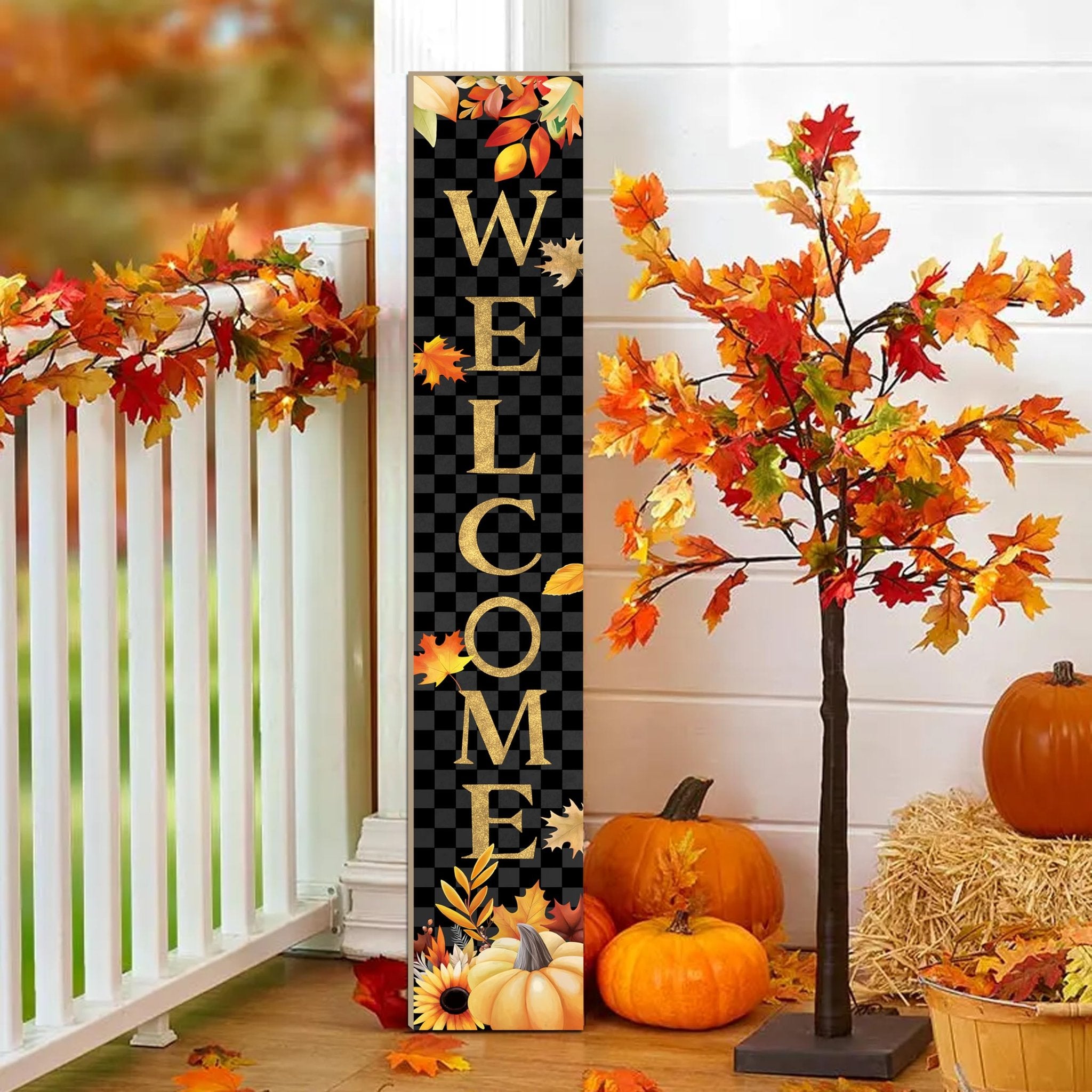 Vertical welcome sign with autumn leaves and pumpkins on a porch railing