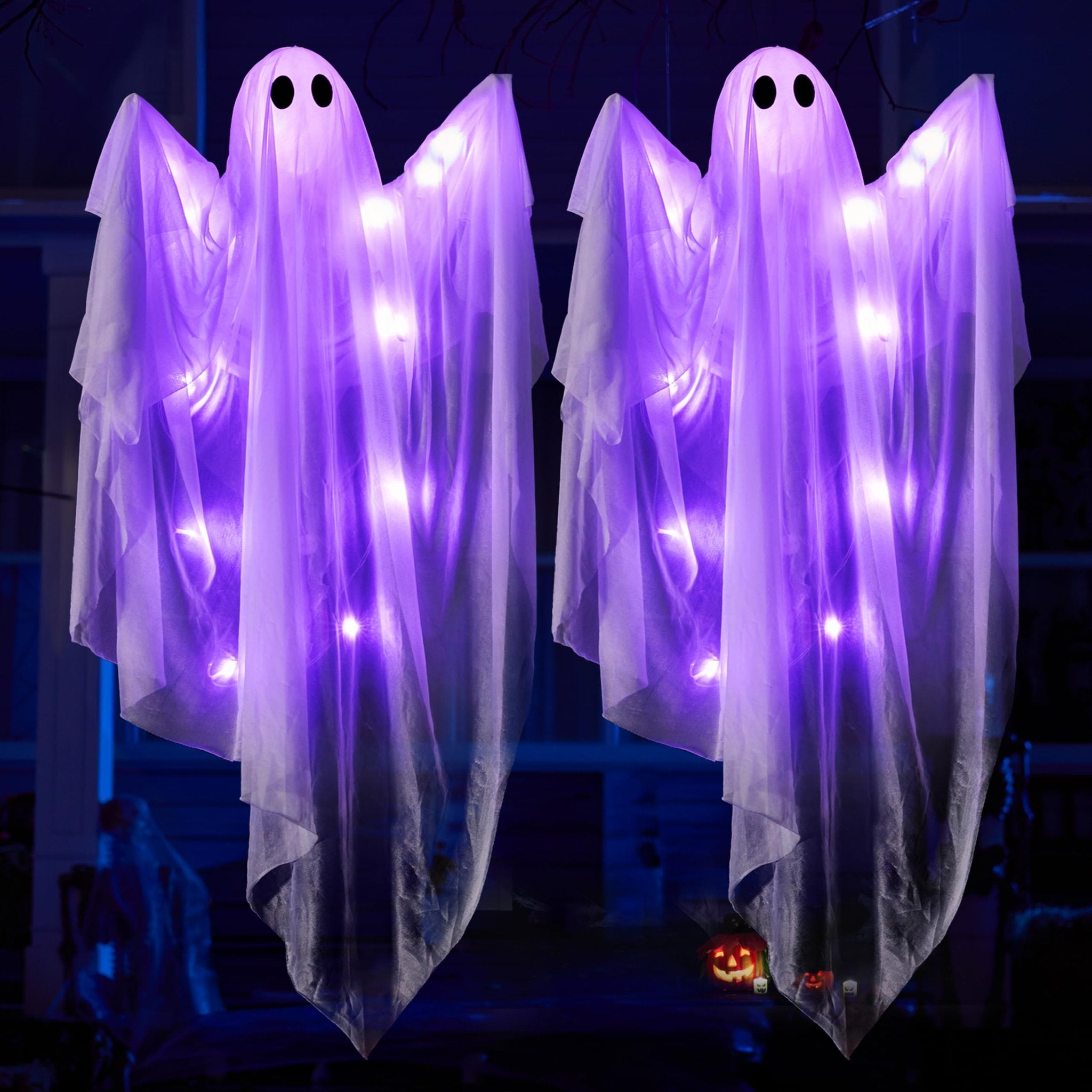 Two light-up hanging ghost decorations with purple LEDs, displayed outdoors at night.