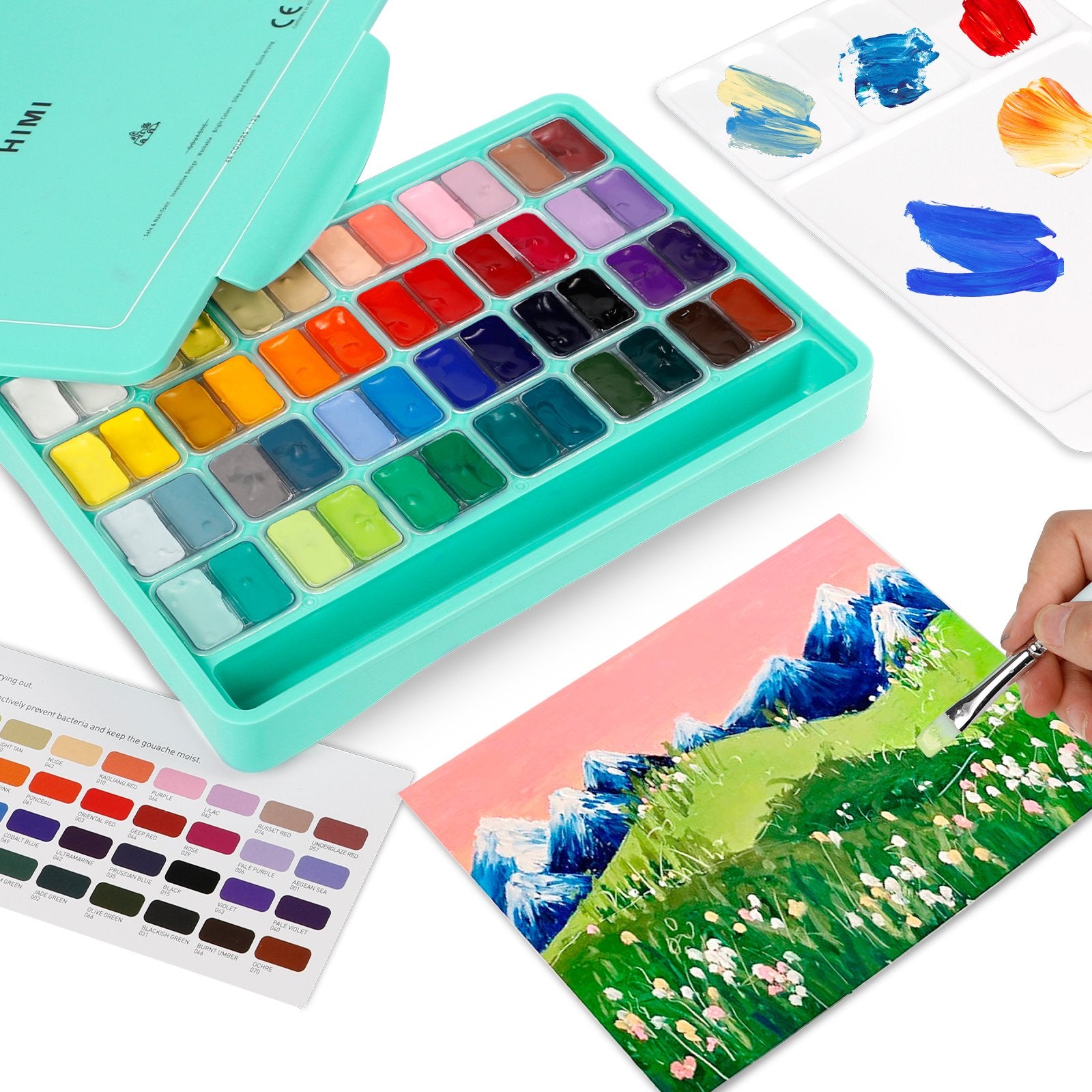Gouache paint set with 48 colors open, showing paint pans, a palette with swatches, and a painting in progress with a brush.