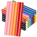 Assorted colored mini hot glue sticks fanned out on a white background, showing pink, orange, red, black, green, blue, yellow, and purple.