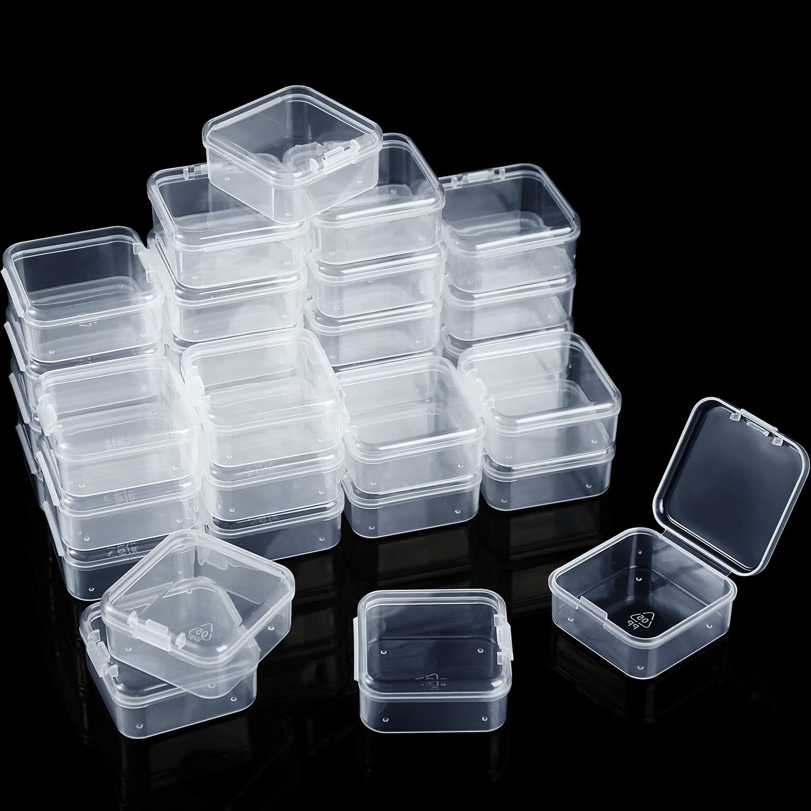Stack of clear plastic storage boxes with hinged lids on a black background, one box open.
