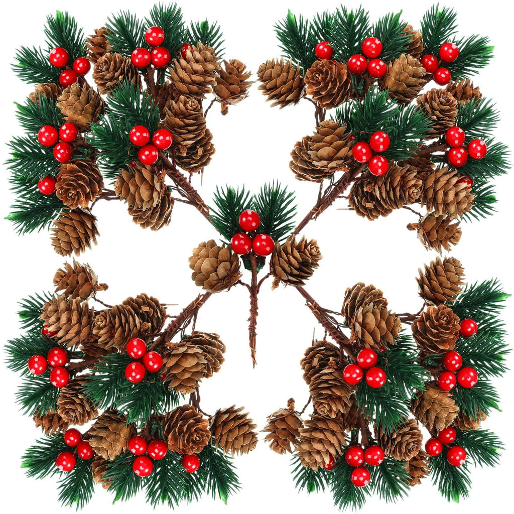 Four artificial pine branch sprays with pine cones and red berries arranged in a symmetrical pattern on a white background.