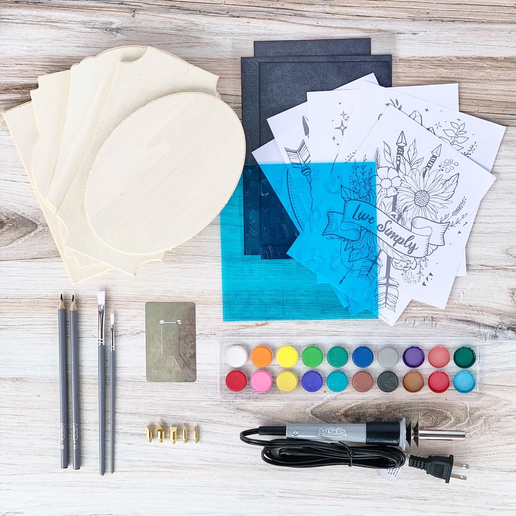 Wood burning kit contents including wood plaques, pencils, brushes, watercolor paints, stencils, and a wood burner pen with tips.