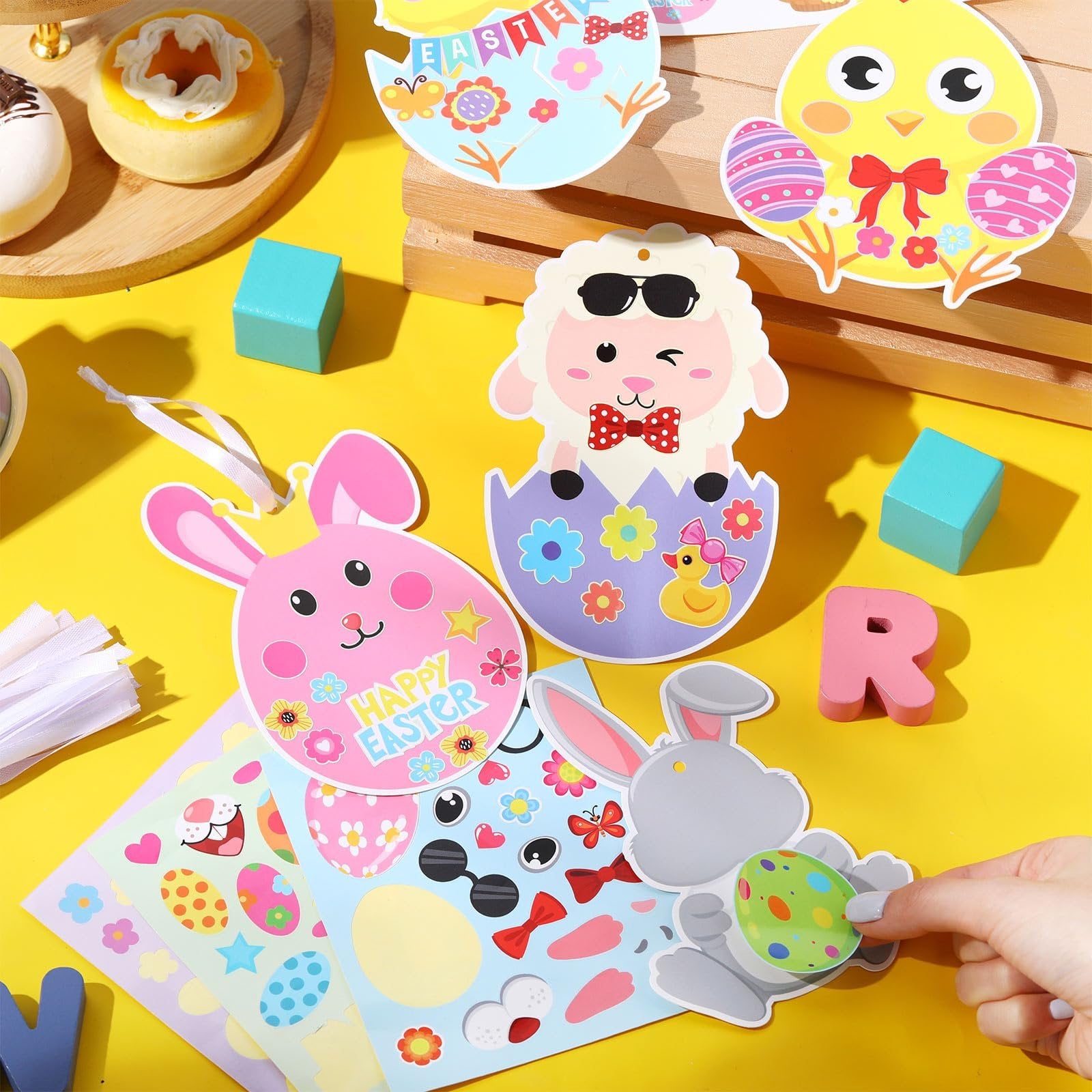 Easter cardstock ornament craft kits with stickers and hanging ropes on a yellow background