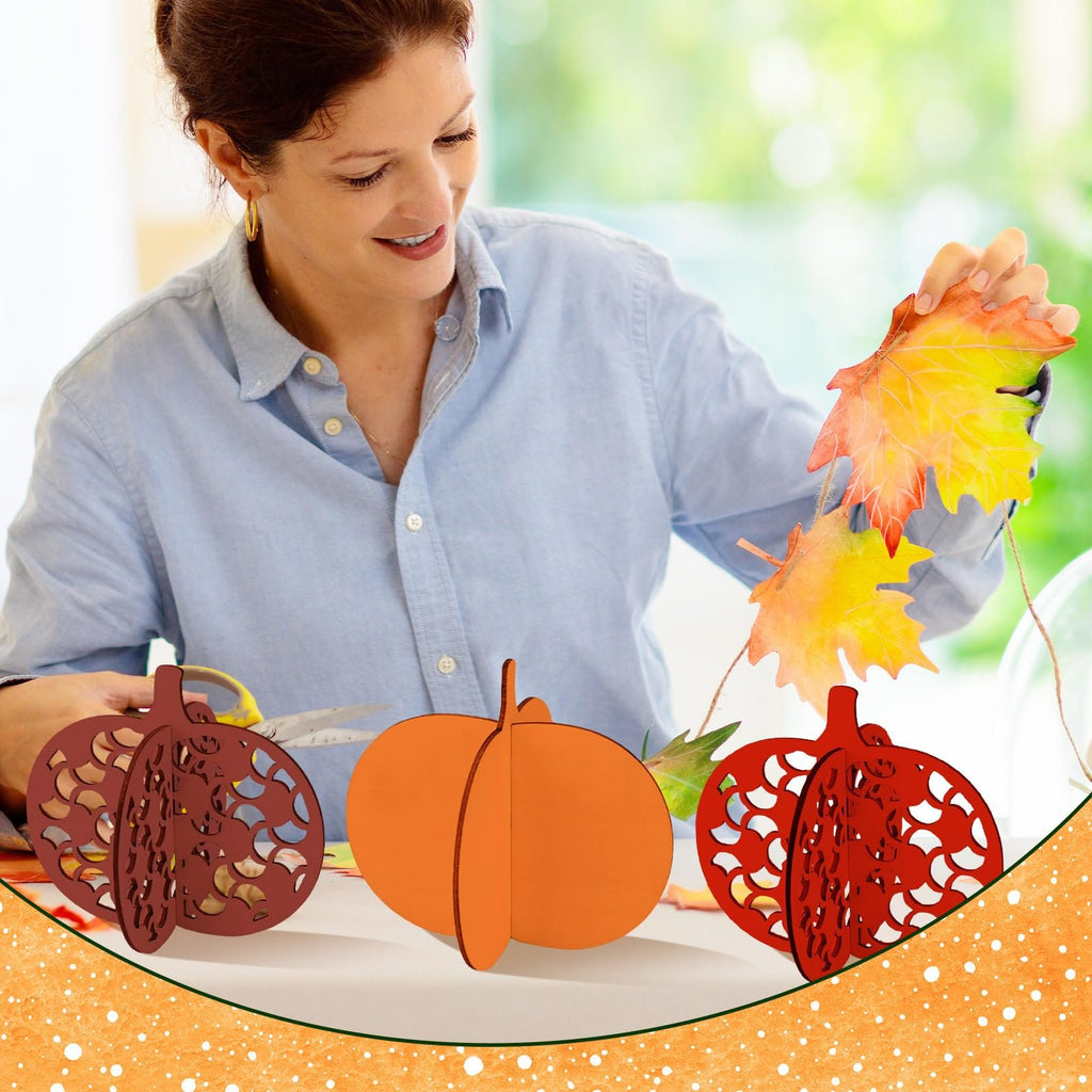 Woman crafting fall wooden pumpkins and autumn leaves indoors