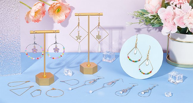Assortment of DIY earring components and finished earrings on a blue surface with floral accents.