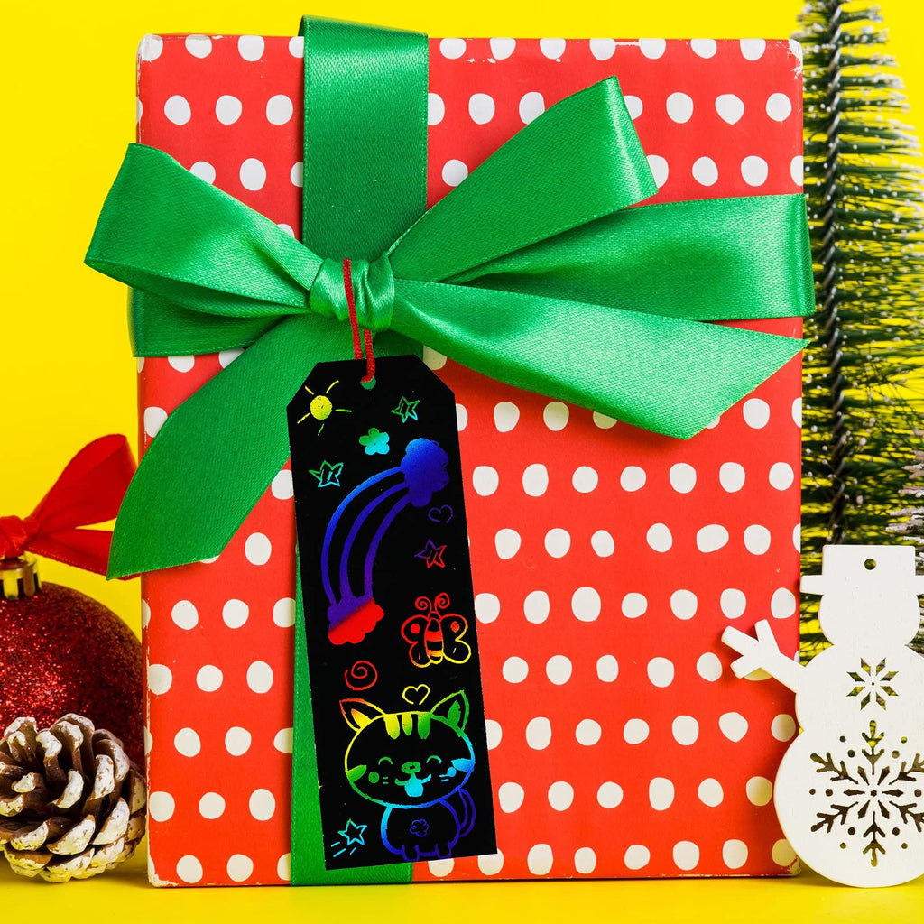 Scratch art bookmark with cat and rainbow designs hanging from a red and white polka dot gift box with green ribbon.