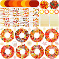 Autumn wreath craft kit components including cardboard circles, stickers, pom-poms, and ribbon, with four completed sample wreaths.