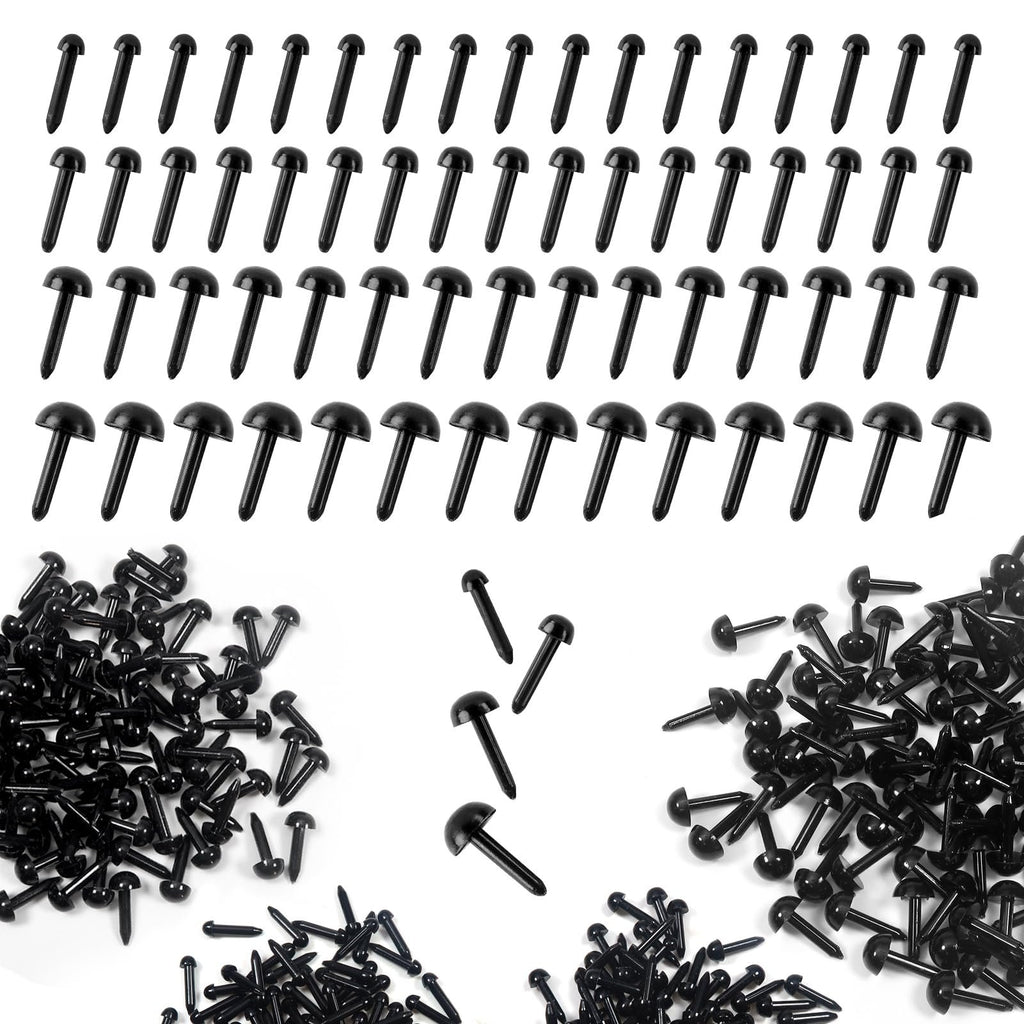 Black plastic craft eyes in various sizes scattered and arranged on a white background.