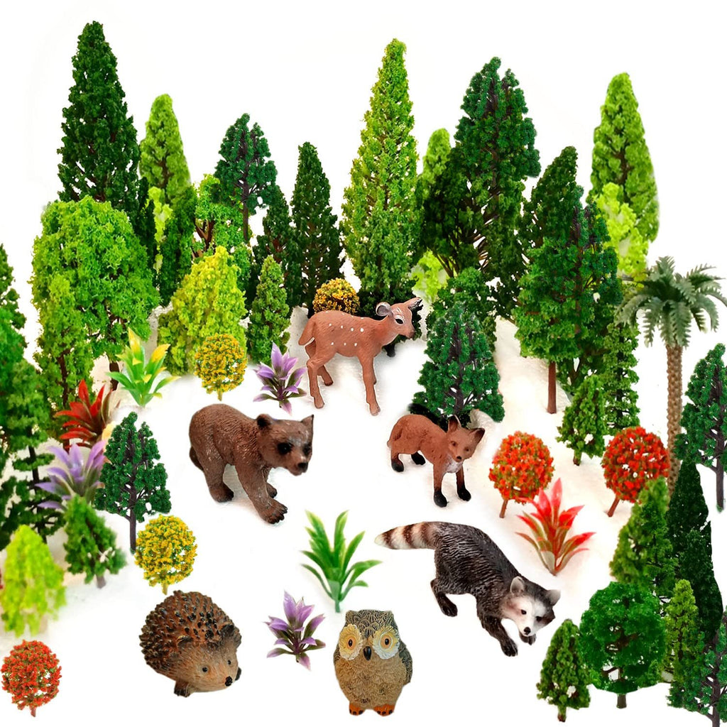 Assortment of miniature plastic forest animals and trees on a white background.