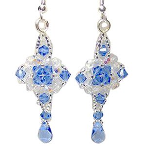 Pair of blue and clear faceted bicone crystal glass bead earrings with silver findings, close-up studio shot.