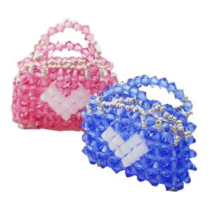 Two beaded purses, one pink and one blue, with white heart designs, isolated on a white background.