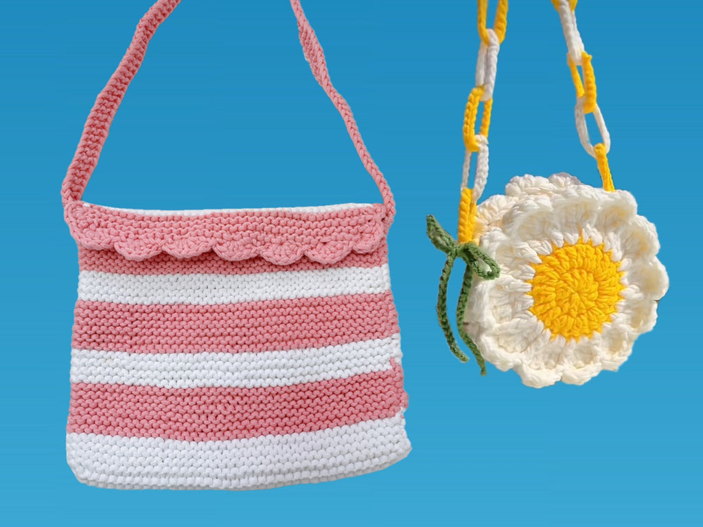 Two crocheted bags, one striped pink and white, the other a white daisy with a yellow center, against a blue background.