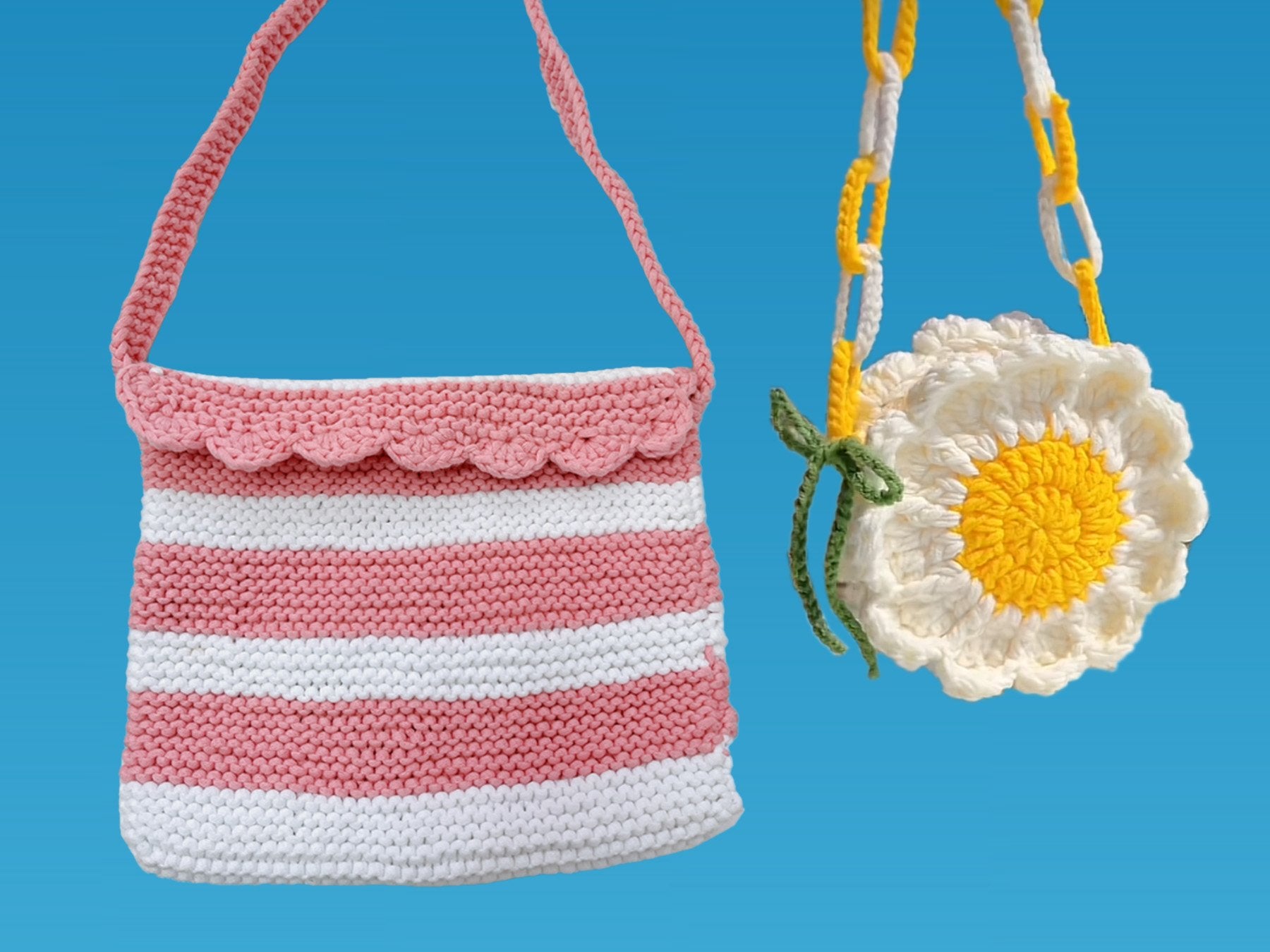 Two crocheted bags, one striped pink and white, the other a white daisy with a yellow center, against a blue background.