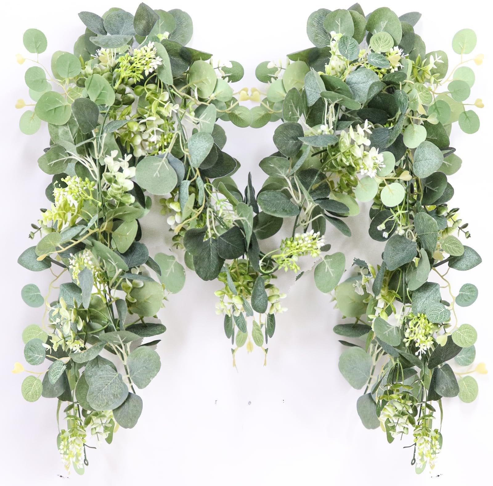 Artificial eucalyptus garland with white blooms draped against a white background.