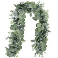 Faux eucalyptus garland with grey-green silk leaves and plastic vine on a white background