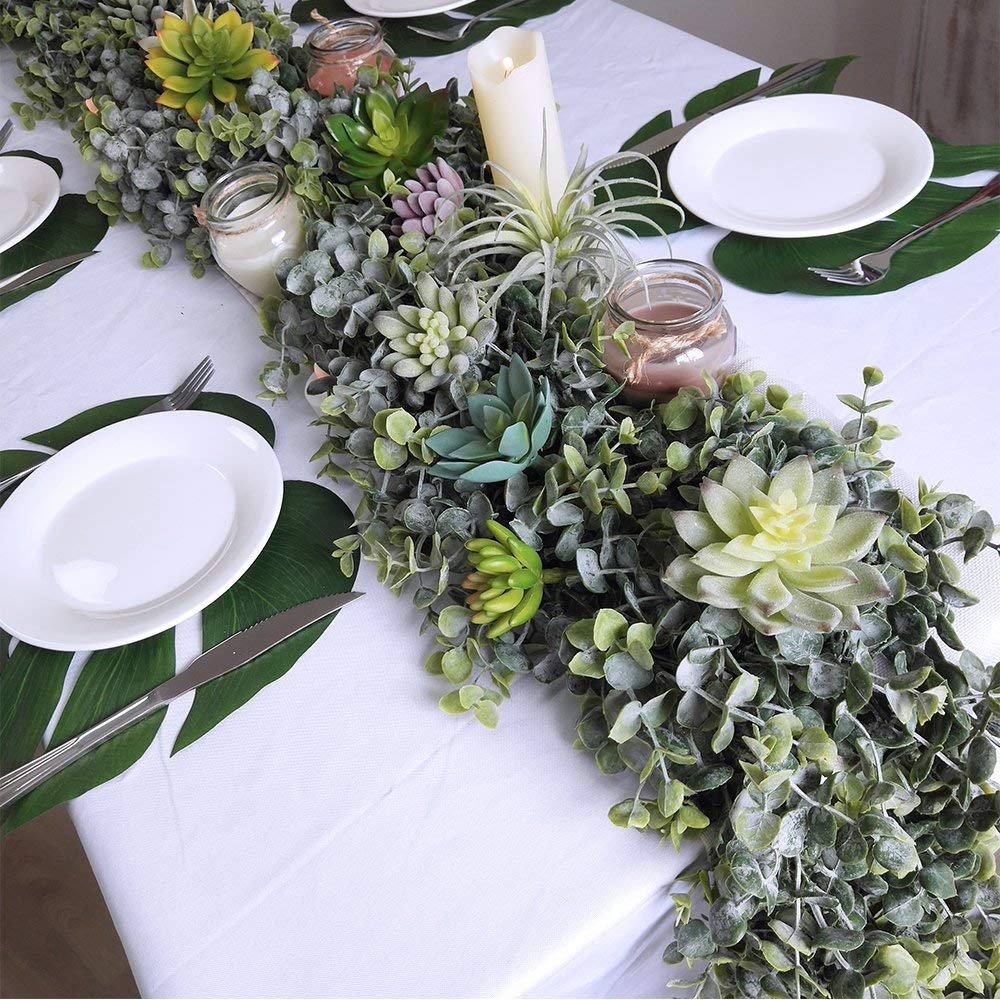 Faux eucalyptus and succulent garland centerpiece on a white tablecloth with place settings