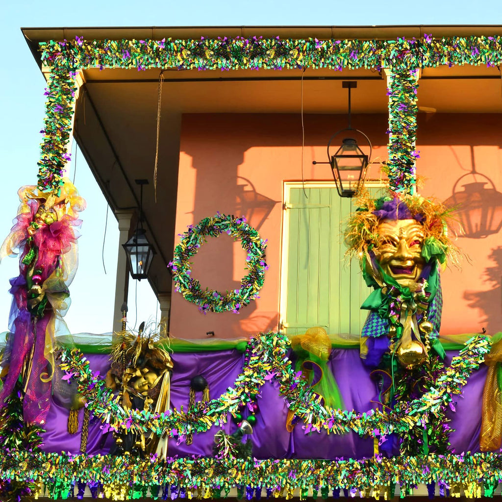 Mardi Gras balcony decorated with purple, green, and gold tinsel garlands, masks, and a wreath.
