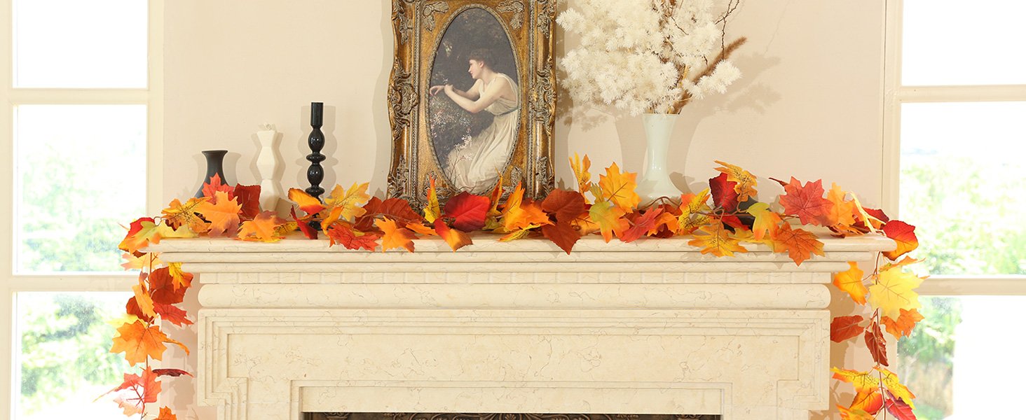 Artificial maple leaf garland with orange, yellow, and red leaves draped over a fireplace mantel.