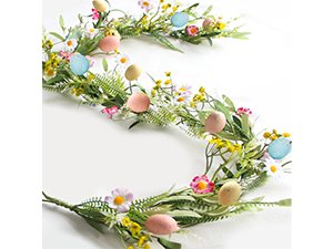 Artificial blue rose vine garland with small pink and yellow flowers and pastel Easter eggs, draped in an S-shape.
