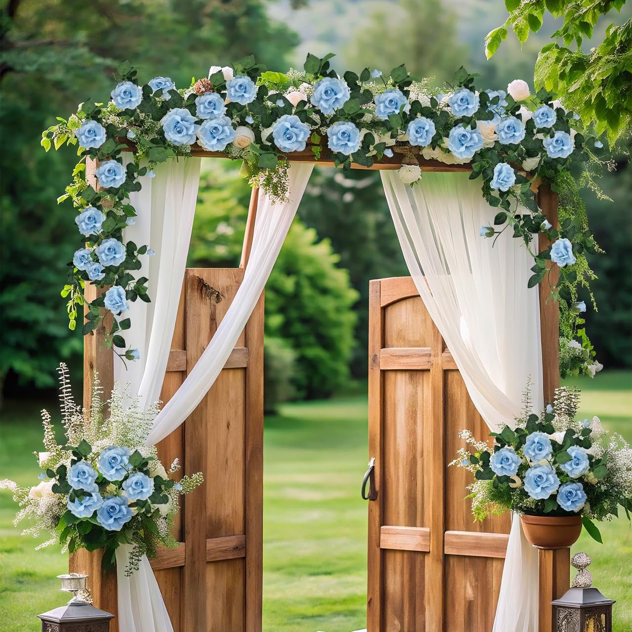 Wooden wedding arch decorated with artificial blue roses and white drapery, set in a garden.