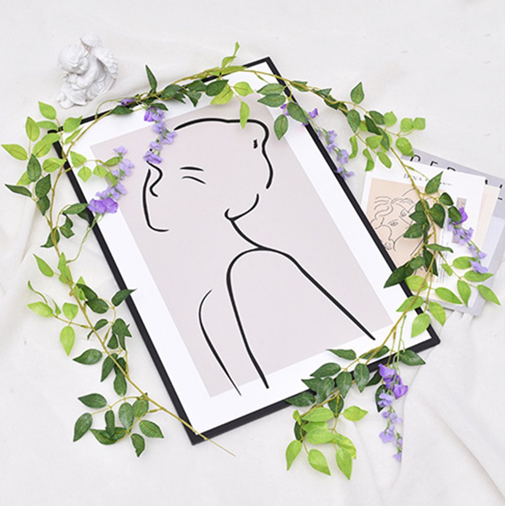 Artificial purple wisteria garland draped over a framed abstract line art print