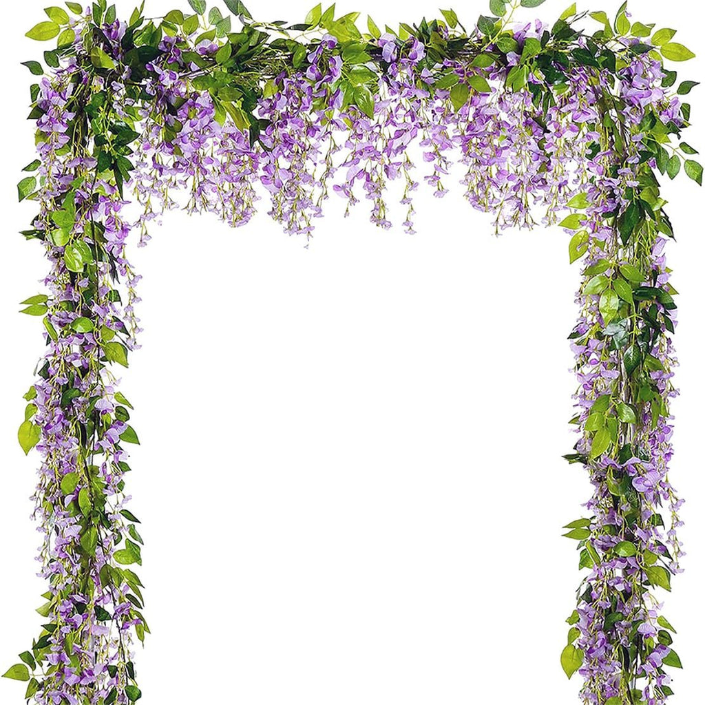 Artificial purple wisteria garland with green leaves draped in an arch shape against a white background.
