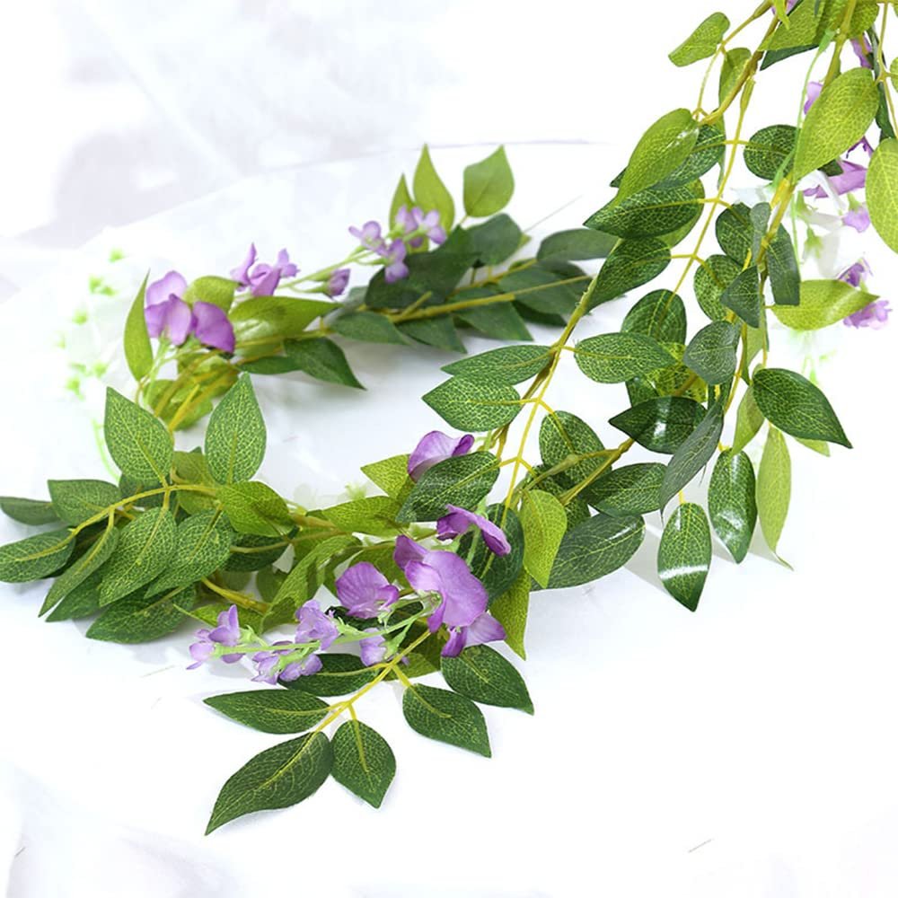 Artificial purple wisteria garland with green leaves on a white background