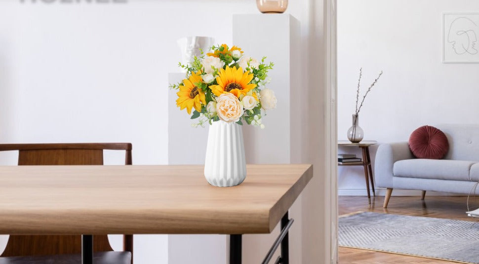 Silk sunflower and peony bouquet in a white vase on a wooden table