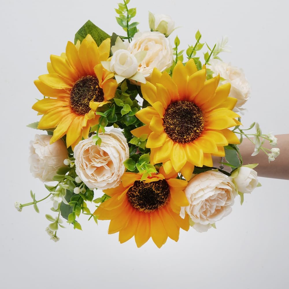 Silk sunflower and peony bouquet held by a hand against a white background.